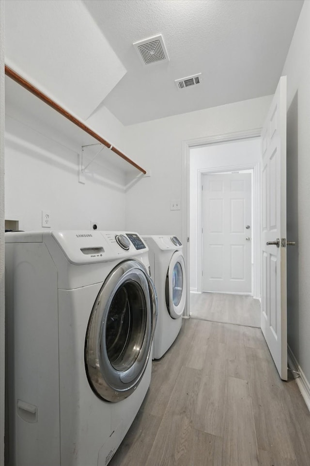 1228 Carriage Creek Dr, Desoto, TX 75115 - clothes washing area featuring light wood-type flooring and washing machine and clothes dryer