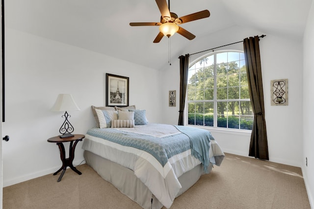 bedroom featuring lofted ceiling, light colored carpet, baseboards, and a ceiling fan