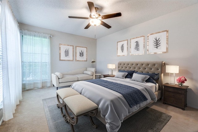 bedroom with light colored carpet, a textured ceiling, and ceiling fan