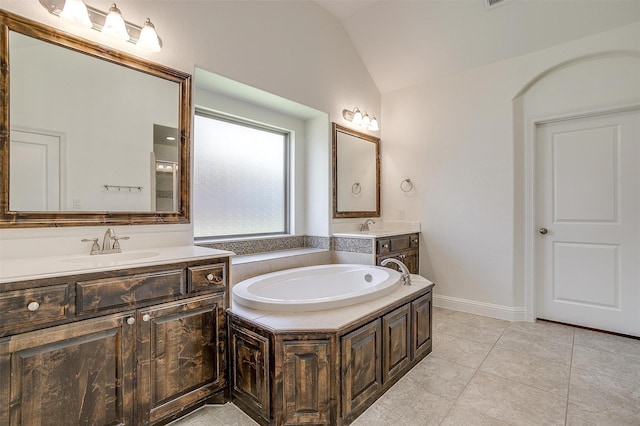 5232 Buffalo Gap Trl, Fort Worth, TX 76126 - bathroom featuring lofted ceiling, a garden tub, two vanities, and tile patterned floors