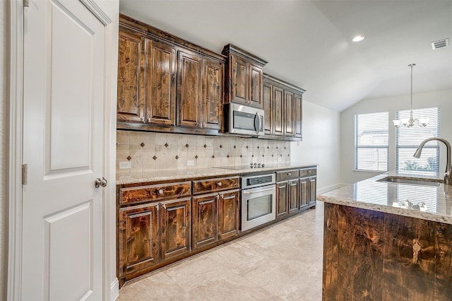 5232 Buffalo Gap Trl, Fort Worth, TX 76126 - kitchen featuring appliances with stainless steel finishes, a sink, vaulted ceiling, backsplash, and dark brown cabinets