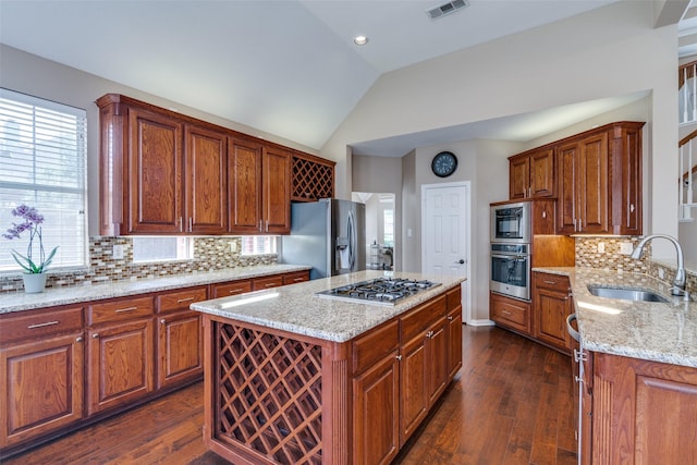 2001 Longfellow Ln, Flower Mound, TX 75028 - kitchen with appliances with stainless steel finishes, a sink, lofted ceiling, light stone counters, and dark wood-style flooring
