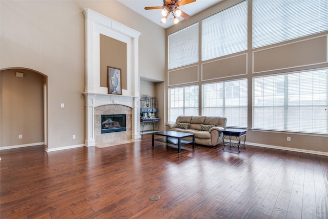 2001 Longfellow Ln, Flower Mound, TX 75028 - living area featuring a ceiling fan, a high ceiling, wood finished floors, arched walkways, and a tile fireplace