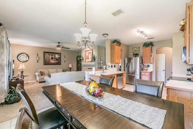 4820 Rum St, Fort Worth, TX 76244 - dining area with arched walkways, a ceiling fan, a chandelier, and light carpet