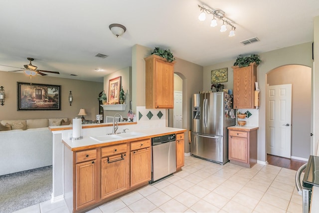 4820 Rum St, Fort Worth, TX 76244 - kitchen with appliances with stainless steel finishes, arched walkways, open floor plan, a sink, and ceiling fan