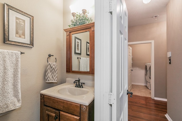 4820 Rum St, Fort Worth, TX 76244 - bathroom featuring vanity, wood finished floors, washer and clothes dryer, and baseboards