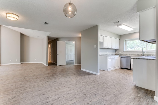 kitchen with stainless steel dishwasher, open floor plan, white cabinetry, a textured ceiling, and light wood-type flooring