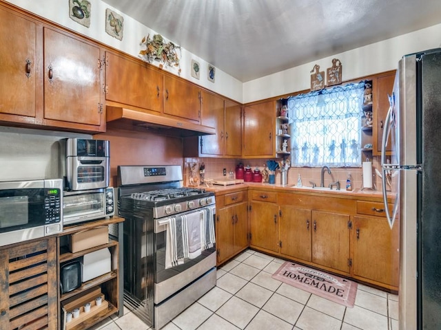 6802 Seco Blvd, Dallas, TX 75217 - kitchen with stainless steel appliances, brown cabinets, a sink, tasteful backsplash, and light tile patterned floors