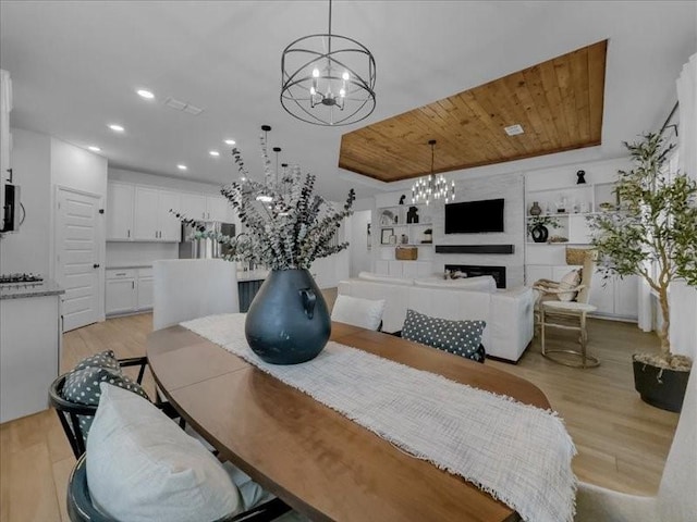 3605 Keechi Creek Dr, Celina, TX 75078 - dining area featuring a chandelier, light wood-type flooring, wooden ceiling, recessed lighting, and a fireplace