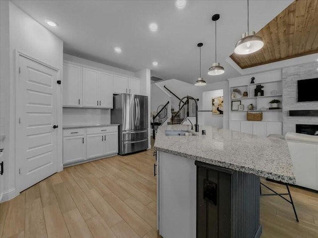 3605 Keechi Creek Dr, Celina, TX 75078 - kitchen with freestanding refrigerator, light wood-style floors, open floor plan, white cabinetry, and recessed lighting