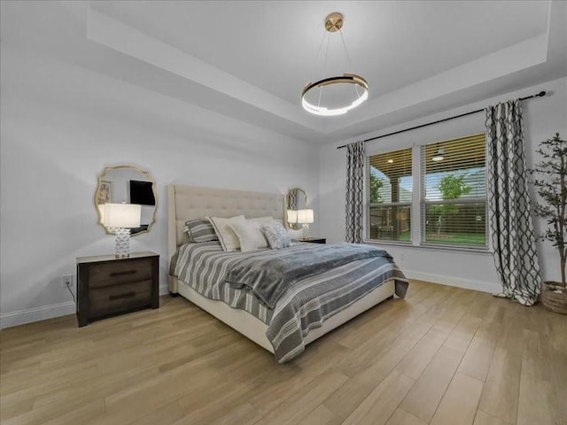 3605 Keechi Creek Dr, Celina, TX 75078 - bedroom with a tray ceiling, light wood-type flooring, and baseboards