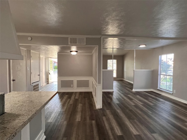 unfurnished dining area with healthy amount of natural light, baseboards, dark wood-type flooring, and crown molding