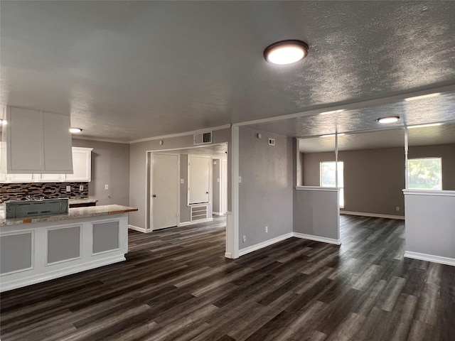 kitchen with dark wood-type flooring, decorative backsplash, white cabinets, light countertops, and baseboards
