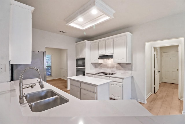 9103 Aristocrat Ln, Frisco, TX 75033 - kitchen with a sink, black appliances, under cabinet range hood, white cabinetry, and light wood finished floors