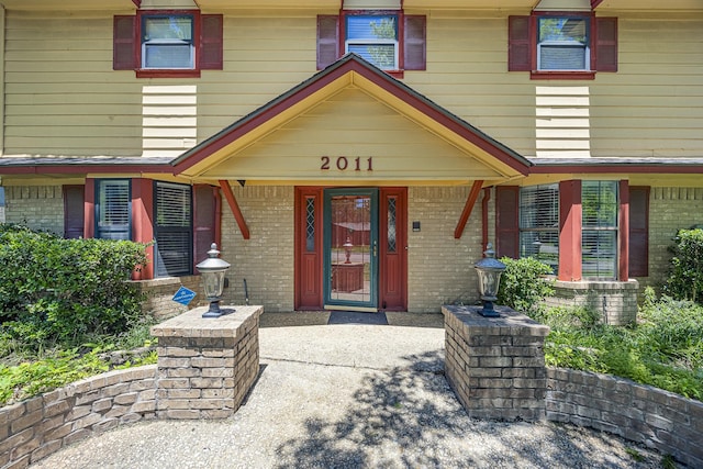 2011 Woodlawn St, Gainesville, TX 76240 - view of exterior entry featuring brick siding and a porch