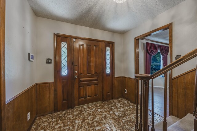 2011 Woodlawn St, Gainesville, TX 76240 - foyer featuring wood walls, a wainscoted wall, and a textured ceiling