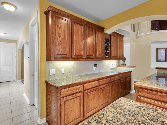 1217 Mandeville Dr, Murphy, TX 75094 - kitchen with arched walkways, light tile patterned floors, decorative backsplash, and tile counters