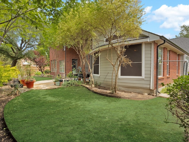 1217 Mandeville Dr, Murphy, TX 75094 - back of property featuring a lawn, brick siding, and a patio area
