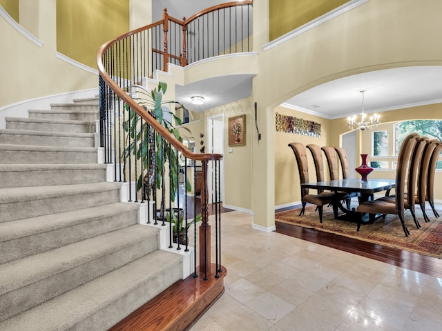 1217 Mandeville Dr, Murphy, TX 75094 - stairway with arched walkways, crown molding, a chandelier, baseboards, and a high ceiling