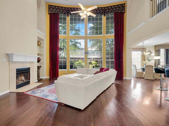 1217 Mandeville Dr, Murphy, TX 75094 - living area with a high ceiling, ceiling fan, a tile fireplace, a chandelier, and hardwood / wood-style floors
