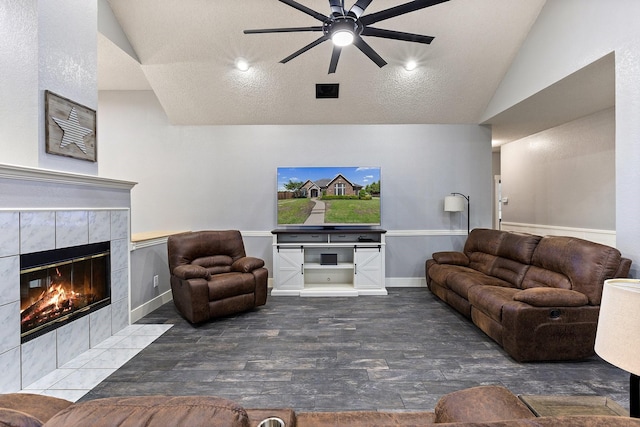 7601 Silverthorn, Rowlett, TX 75089 - living room with vaulted ceiling, a ceiling fan, wood finished floors, a tiled fireplace, and baseboards
