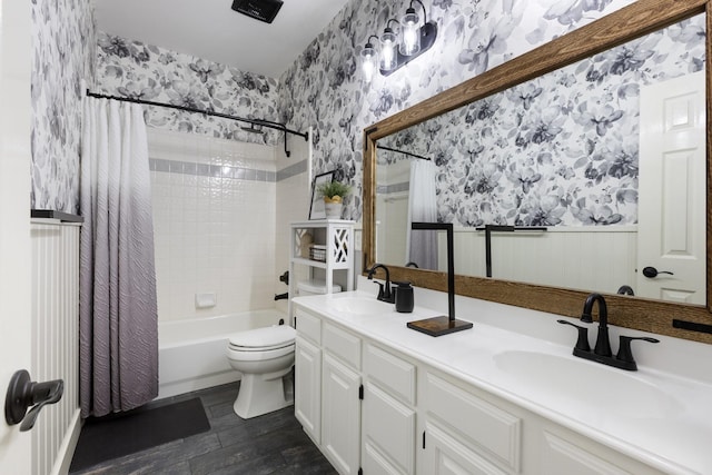 7601 Silverthorn, Rowlett, TX 75089 - bathroom featuring wallpapered walls, toilet, shower / tub combo with curtain, double vanity, and a wainscoted wall