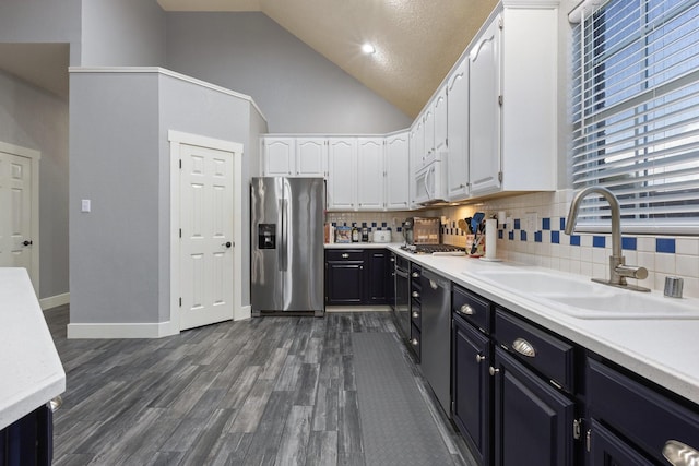 7601 Silverthorn, Rowlett, TX 75089 - kitchen with appliances with stainless steel finishes, a sink, white cabinetry, tasteful backsplash, and high vaulted ceiling