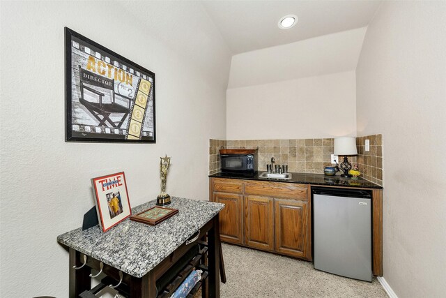 2401 Portwood Way, Fort Worth, TX 76179 - kitchen with freestanding refrigerator, black microwave, tasteful backsplash, brown cabinets, and light carpet
