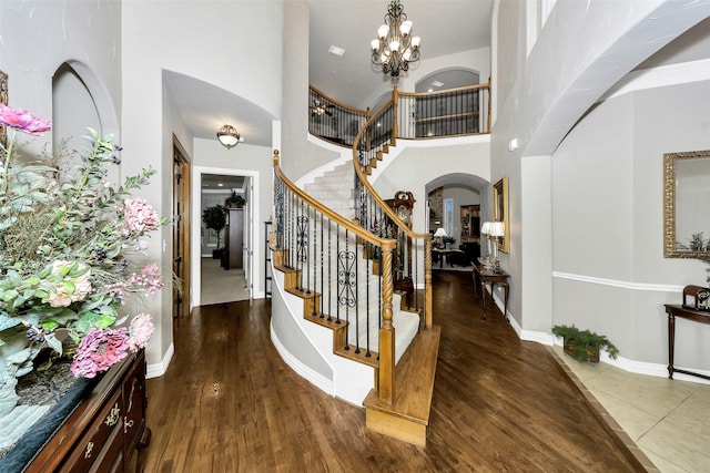 2401 Portwood Way, Fort Worth, TX 76179 - entryway featuring arched walkways, stairs, wood finished floors, a towering ceiling, and a chandelier