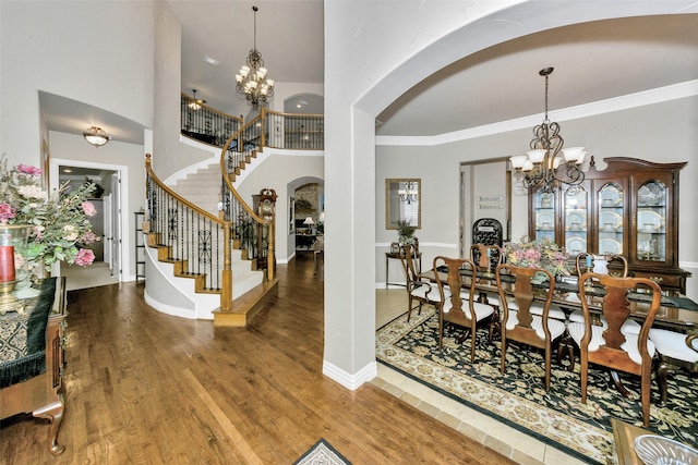 2401 Portwood Way, Fort Worth, TX 76179 - foyer entrance with arched walkways, a chandelier, stairway, wood finished floors, and crown molding