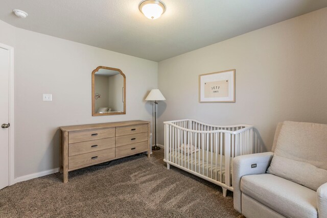 3101 Gilchrist Dr, Waco, TX 76655 - bedroom featuring dark carpet, a nursery area, and baseboards