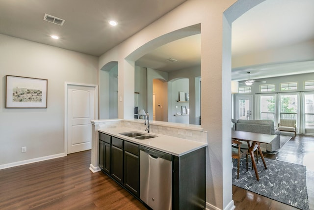 3101 Gilchrist Dr, Waco, TX 76655 - kitchen with a sink, arched walkways, stainless steel dishwasher, light countertops, and dark wood-style floors