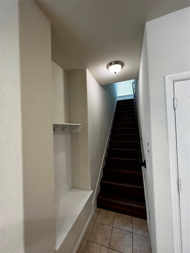 9105 Edenberry Ln, Fort Worth, TX 76179 - stairs with tile patterned floors, baseboards, and a textured ceiling