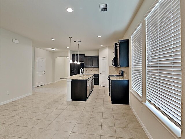 9105 Edenberry Ln, Fort Worth, TX 76179 - kitchen featuring stove, backsplash, arched walkways, a sink, and recessed lighting