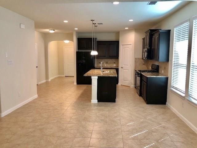 9105 Edenberry Ln, Fort Worth, TX 76179 - kitchen featuring black appliances, arched walkways, tasteful backsplash, healthy amount of natural light, and recessed lighting