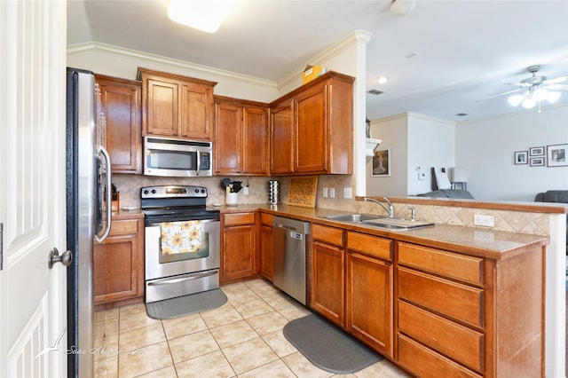 390 Sugarberry Ave, Abilene, TX 79602 - kitchen with stainless steel appliances, a sink, a peninsula, decorative backsplash, and ornamental molding