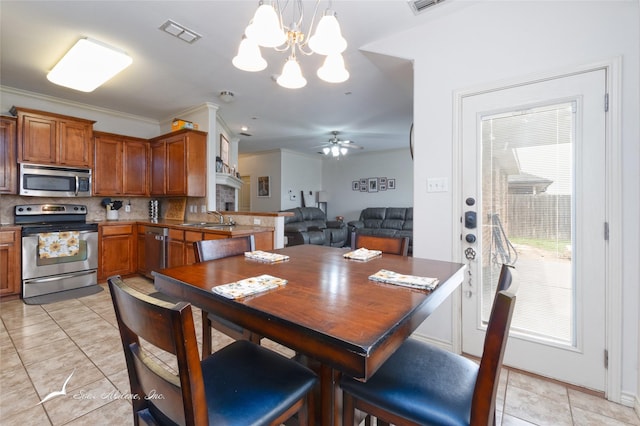390 Sugarberry Ave, Abilene, TX 79602 - dining area with a chandelier, light tile patterned flooring, a ceiling fan, and crown molding