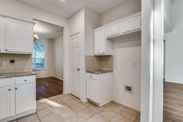 kitchen featuring decorative backsplash, stone countertops, white cabinets, and light tile patterned floors