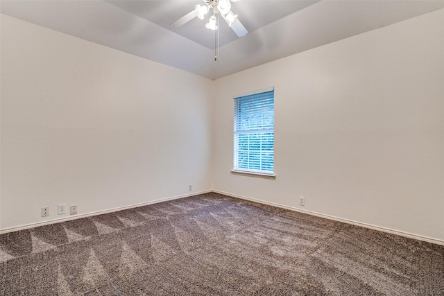unfurnished room featuring dark carpet, a ceiling fan, and baseboards