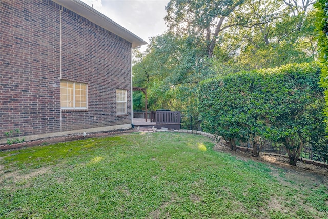 view of grassy yard featuring a deck