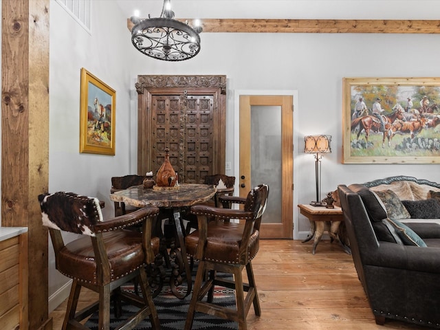 dining room with a chandelier, light wood-style floors, and baseboards