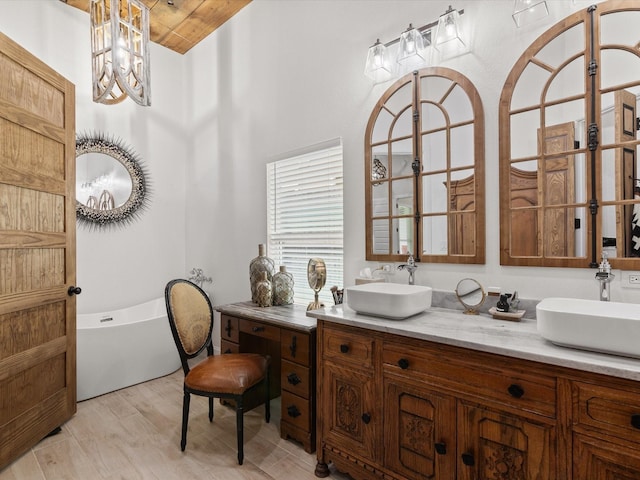 bathroom with a freestanding bath, double vanity, and a chandelier