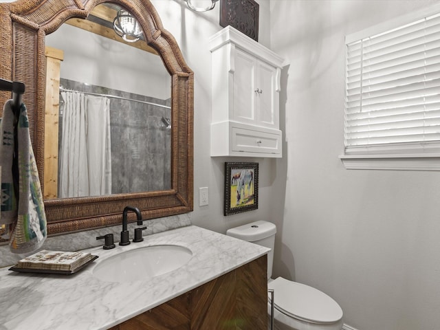 bathroom featuring toilet, vanity, curtained shower, and baseboards