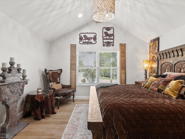 bedroom featuring light wood-type flooring, a chandelier, lofted ceiling, and baseboards