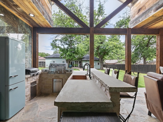 view of patio featuring area for grilling, fence, and exterior bar