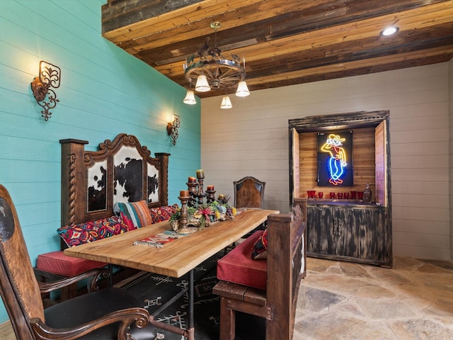 dining room featuring stone floors and wood walls