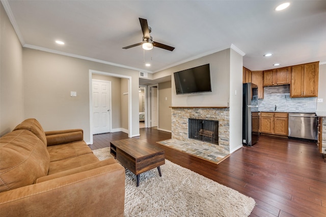 living room featuring a ceiling fan, dark wood finished floors, recessed lighting, crown molding, and baseboards
