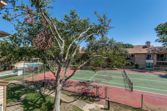 view of tennis court featuring fence