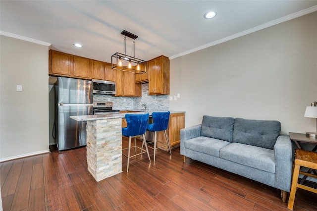 kitchen with appliances with stainless steel finishes, ornamental molding, open floor plan, backsplash, and light countertops