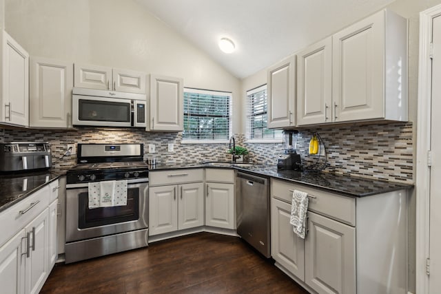 400 Crooked Ln, Mesquite, TX 75149 - kitchen featuring stainless steel appliances, vaulted ceiling, a sink, decorative backsplash, and white cabinetry